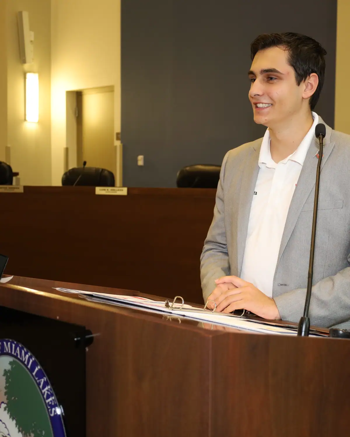 A student volunteer runs the room from the municipal podium.