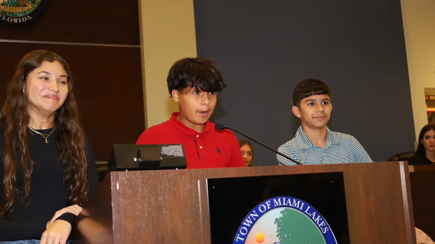 Students lead the closing session from the chamber dais.