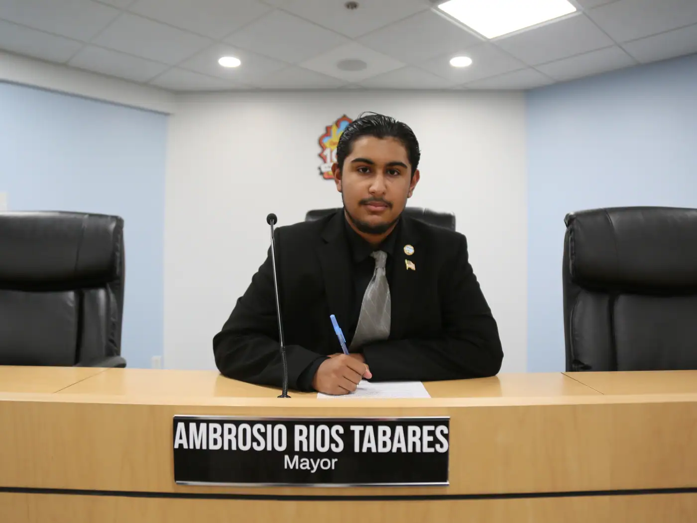 A student takes the mayor's seat, nameplate and all.