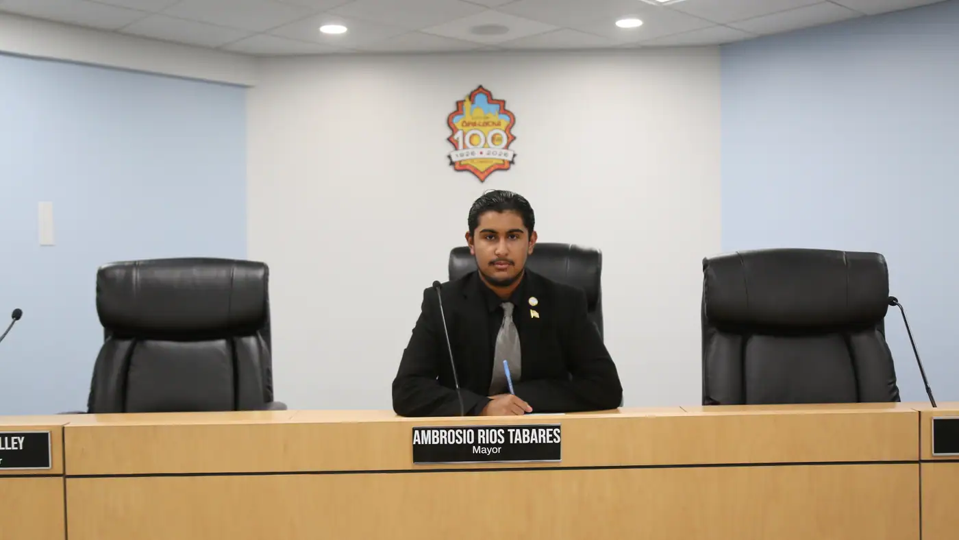 Presiding from the center chair of a council chamber.